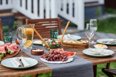 Yaz partisi için açık havada taze meyve ve böğürtlenlerle hazırlanmış şenlikli yemek masasının kapanışı.