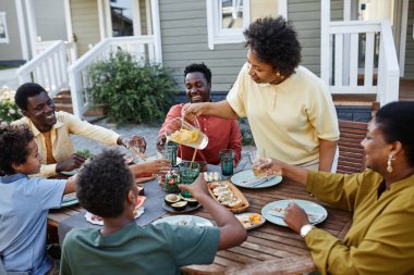 Aile toplantısına ev sahipliği yaparken limonata içen Afrikalı Amerikalı kadının portresi.