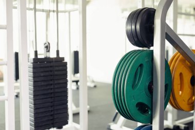 Ağırlık kaldırmak ve vücut geliştirmek için modern spor salonundaki ağırlık kaldırma ekipmanlarını kapatın.