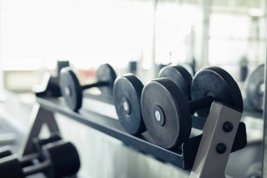 Spor salonunda spor eğitimi için metal dambılların yakın çekimi.