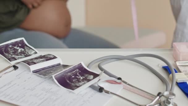 无法辨认的女妇科医生在预约的医疗检查中对孕妇进行腹部测量 并将婴儿超声波扫描放在桌子上 — 图库视频影像