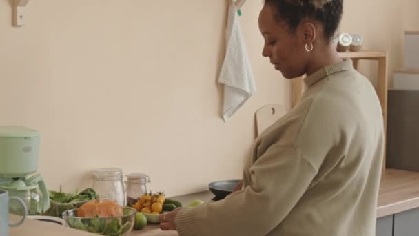 身着舒适针织衣服的年轻怀孕黑人妇女中午在家做健康蔬菜沙拉的中档镜头 — 图库视频影像