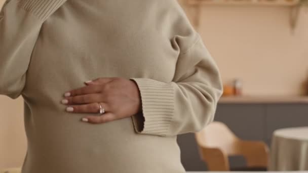 年轻的非洲裔美国妇女在家里的闲暇时间 一边用无线耳机跳着舞 一边抚摸着怀孕的肚子 — 图库视频影像