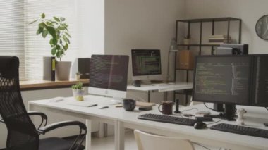 Geniş siyah-beyaz yazılım mühendislerinin çekimleri siyah pc monitörlerinde çalışan program kodlarıyla uzay ofisi içini açmaz.