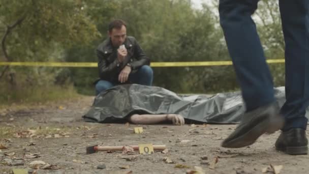 Homem Detetive Caucasiano Sentado Voltas Por Cadáver Sob Saco Plástico — Vídeo de Stock