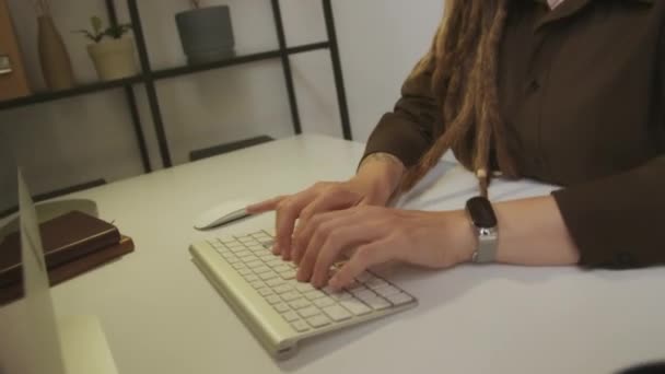 若い焦点を当てた白人女性ソフトウェアエンジニアのハンドヘルドタイルショット コンピュータモニターを見て 現代のプログラマオフィスで働いている間ワイヤレスキーボードにタイプする眼鏡で — ストック動画