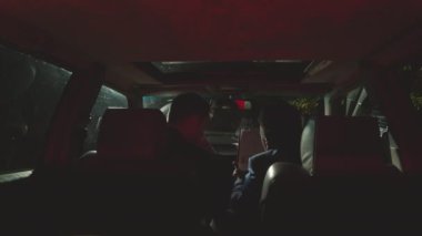 İki polis memurunun gece arabada oturup, suç dosyası incelerken ve tartışırkenki görüntüsü.