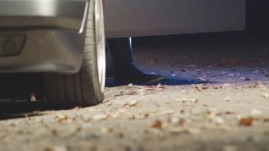 Tanımlanamayan erkek polisin gece suç işlemek için yanıp sönen mavi ve kırmızı ışıklarla polis arabasından inmesi