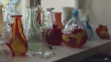 Yaratıcı cam üfleme atölyesinde pencere kenarındaki renkli sürahi ve vazolardan çekilen kimse yok.