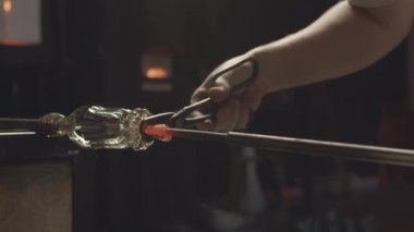Paslanmaz çelik makas ve spatula kullanılarak tanınmaz hale getirilmiş cam şişe şeklini alarak atölyede cam üfleme tekniğiyle üretilen.