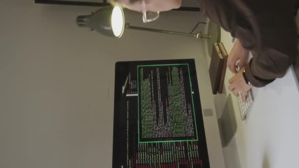 オフィスでソフトウェアエンジニアとして働いている間 眼鏡をかけ ワイヤレスキーボードにプログラムコードを書き込む若い白人女性の垂直媒体の肖像画 — ストック動画