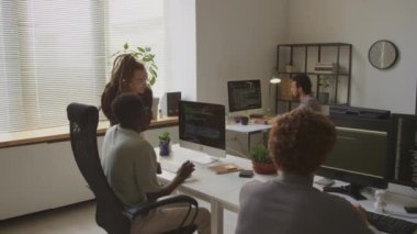 Bilgisayar ekranında html koduna bakan ve diğer yazılım mühendisleriyle modern programcılar ofisinde çalışan çok ırklı meslektaşların arka plan görüntüsü.