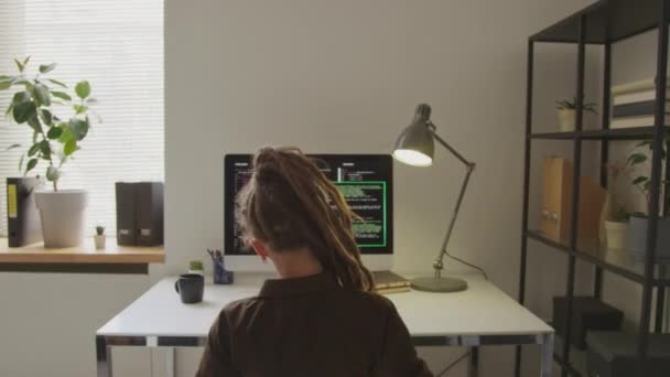 白种人女程序员手挽手 背对背 坐在写字台前写字台上编程时 背视腰部朝上的照片 — 图库视频影像