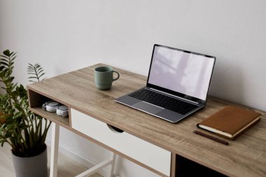 Öğrenci, serbest çalışan ya da dizüstü bilgisayarı, defteri ve fincanı oturma odasının duvarının yanında duran online özel öğretmen.