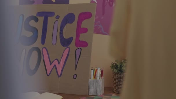 ハンドメイドの正義を撮影した人はいません 屋内の段ボール紙にフェミニストの旗を刻印 — ストック動画