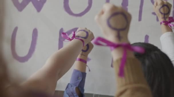 Powolne Nierozpoznawalne Kobiety Wkładające Pięści Fioletowymi Symbolami Feministycznymi Wstążkami Nadgarstek — Wideo stockowe