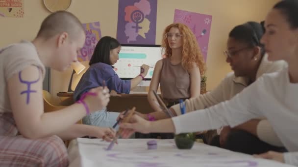 ミディアムショット5人の若い多様な独立した女性が体にフェミニズムのシンボルを描き 一緒にストライキをする準備をしている間に動機づけバナーを作成します — ストック動画