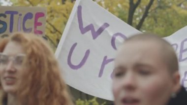 Sokak gösterileri sırasında cinsiyet eşitliği için mücadele eden, güçlendirme posterleri ve pankartlarıyla girişimde bulunan bir grup genç kadın
