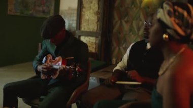 Orta halli yetenekli genç Afrikalı Amerikalı caz grubunun şık kıyafetleri içinde loş ışık ve otantik iç mekan ile kulüpte daireler çizerek akşam konserine hazırlandığı bir fotoğraf.