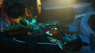 Genç siyahi bir kadının caz grubuyla sahnede çalarken çekilmiş dikey yan görüntüsü.