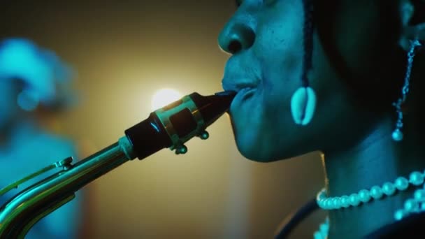 夕方のジャズコンサートでサックスを演奏するアフリカ系アメリカ人女性ミュージシャンのミディアムクローズアップ — ストック動画