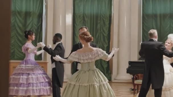 魅力的なビクトリア様式のドレスを魅了する多民族の完全な長さのショット グラマラスなデバンテボールでお互いに踊る — ストック動画