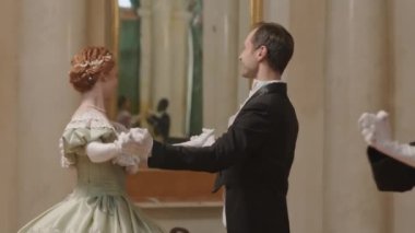 Orta ölçekli mutlu genç aristokrasi üyeleri çiftler halinde dans ediyor ve klasik malikanedeki balo partisinde eşlerini değiştiriyor.