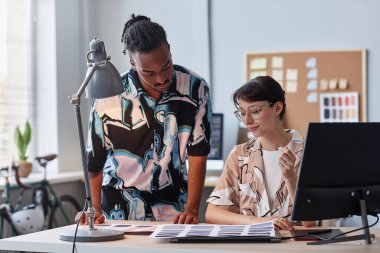 Ofiste renk paletleri seçen iki yaratıcı tasarımcının portresi