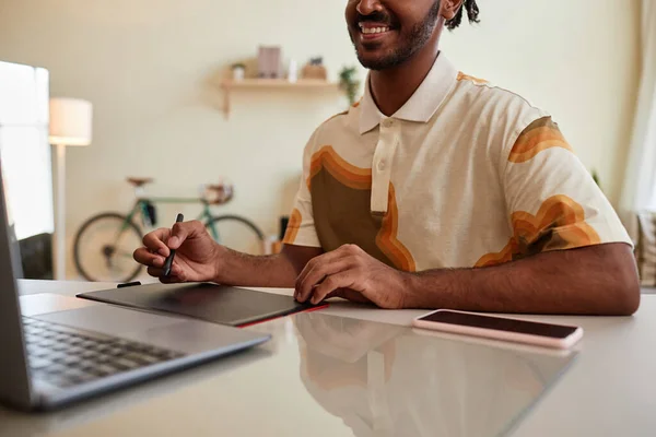 Close up of smiling black man using pen tablet for digital design at home office workplace, copy space