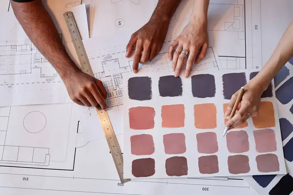 Top view of two architects working on color choice for interior design project