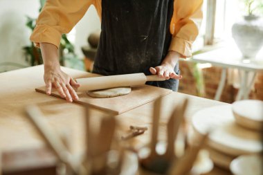 Samimi çömlek atölyesinde el yapımı seramik yapan genç bir kadının yakın çekimi.