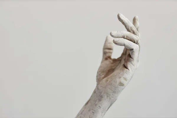 Minimal closeup of male hand covered in white paint or plaster, human art form, copy space