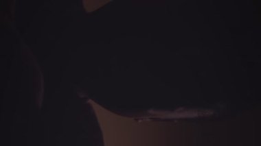 Karanlık oda ışığı yanıp sönerken kabustan çığlık atan korkmuş Afrikalı Amerikalı küçük çocuğun dikey yakın çekimi.