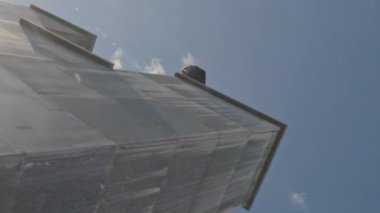 Güneşli bir günde, erkek arkadaşının parkour dublörlüğünü yaptığı beyaz tenli, beyaz bir kızın akıllı telefondaki videosunu dikey çekiyoruz.