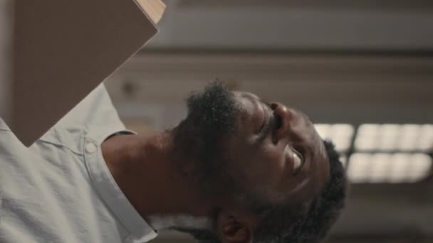 一个年轻的非裔美国人 坐在天主教堂的长椅上 直挺挺地举着胸膛读圣经 抬起头来面对上帝 — 图库视频影像
