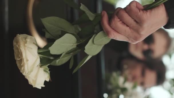 Вертикальний Середній Розріз Невпізнаваної Жінки Тримає Дві Білі Троянди Стоячи — стокове відео