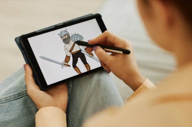Seçici odak noktası, genç kadın dijital ressam Stylus 'un yeni görüntüler yarattığı tablet ekranındaki savaşçı görüntüsü.