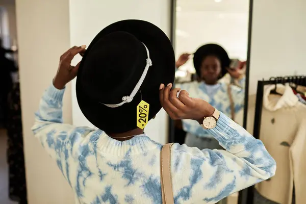 Vista Posterior Joven Mujer Negra Probándose Sombrero Tienda Segunda Mano —  Fotos de Stock