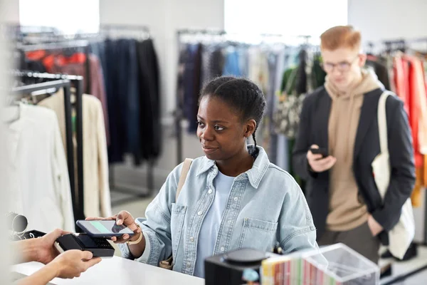 Портрет Улыбающейся Чёрной Женщины Платящей Магазине Одежды Через Смартфон Nfc — стоковое фото