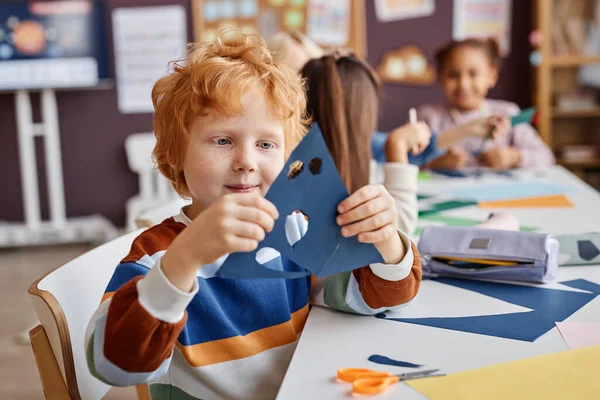 Netter Grundschüler Hält Blaues Papier Mit Löchern Für Augen Und — Stockfoto