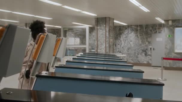 穿着米色长衫的年轻黑人妇女在上班时穿过地铁转门的侧视图中慢镜头 — 图库视频影像