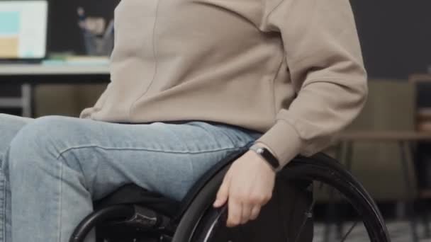 无法辨认的残疾女职员在上班时间坐着轮椅向饮水机走去 并向杯子里倒入清水 — 图库视频影像