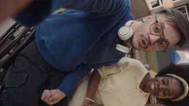 Tekerlekli sandalyedeki beyaz bir adamın iş yerindeki Afrikalı Amerikalı bayan ofis arkadaşıyla video blogu kaydederken çekilmiş el kamerası görüntüsü.