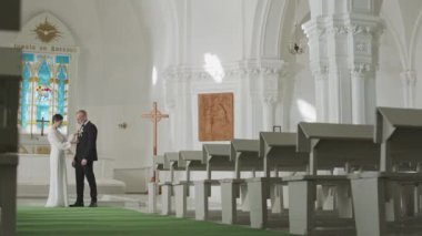 Yaşlı, beyaz, yeni evli çiftin kilisedeki beyaz bankların önünde dikilmesi ve düğün töreninden önce sarılıp yatması.