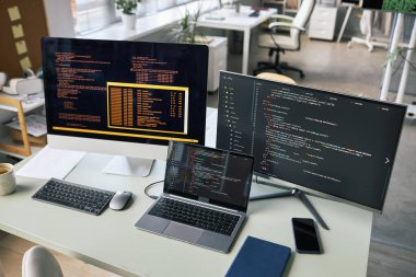 Bilgisayarlar ve laptop yazılım geliştiricisinin ofis masasında.
