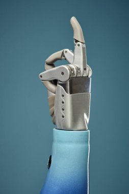 Orta parmağı gösteren protez kol, mavi arkaplanda izole edilmiş.