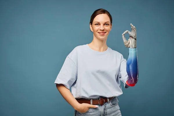 Cheerful Young Woman Bionic Arm Showing Sign Isolated Greyish Blu — Stock Photo, Image