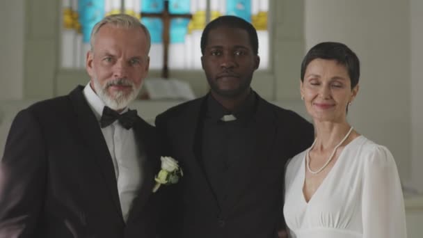 교회에서 결혼식 카메라에 즐거운 코카서스 커플과 사제의 초상화 — 비디오