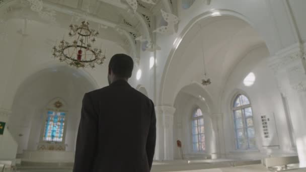 黒いスーツでアフリカ系アメリカ人の男性司祭のゆっくりとした景色 ルーテル教会の祭壇に向かって歩く — ストック動画