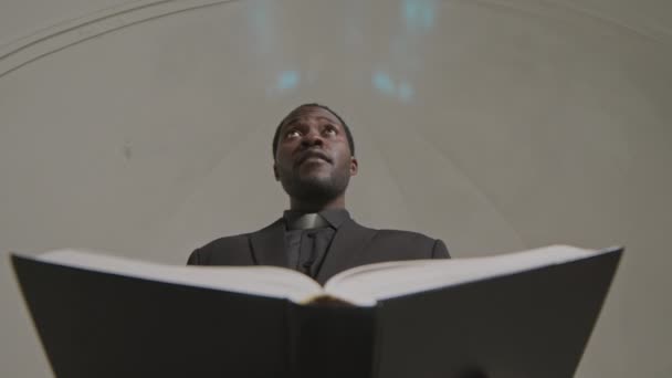 Baixo Ângulo Tiro Jovem Sacerdote Negro Roupa Formal Segurando Bíblia — Vídeo de Stock
